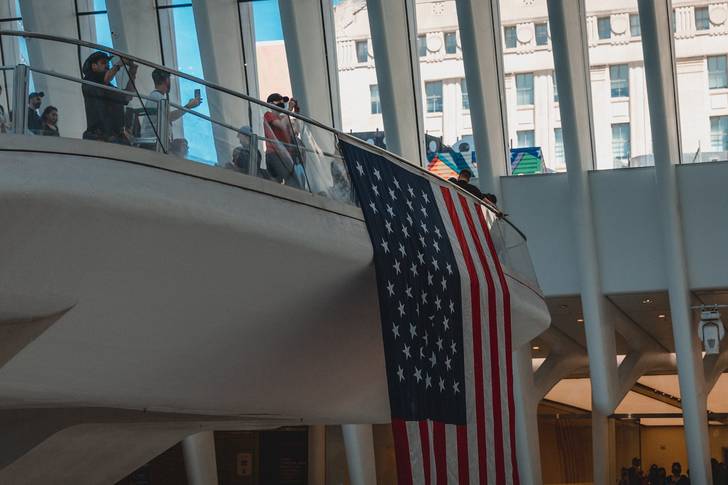 an American flag hangs over a balcony inside the Oculus mall